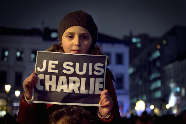 A young girl holding a "Charlie Hebdo," sign in Place Luxembourg, Bruxelles. (Valentina Calà)