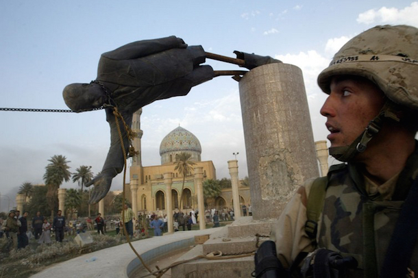 U.S. Marine watches as statue of Saddam Hussein topples in 2003. (Goran Tomasevic/Reuters)