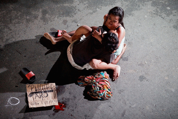 Jennilyn Olayres cradles the body of her partner, who was killed on a street by a vigilante group, according to police. (Czar Dancel/Reuters)