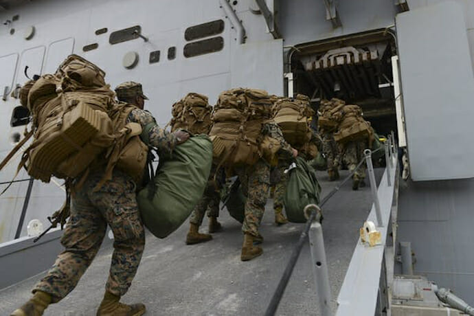U.S. Marines board the amphibious assault ship USS Iwo Jima