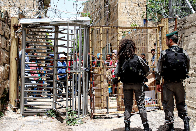 Two Israeli soldiers guard a checkpoint in Hebron