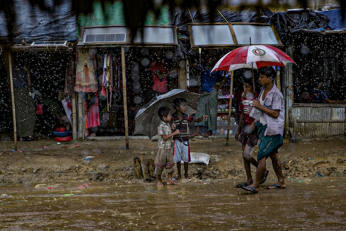 People walk in the rain in Cox's Bazar, Bangladesh