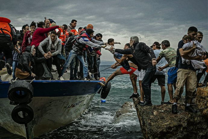 Refugees aboard a fishing boat driven by smugglers reach Lesbos Island, Greece