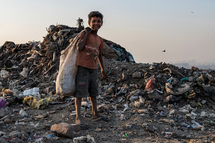 A young boy collects plastic waste for recycling in New Delhi