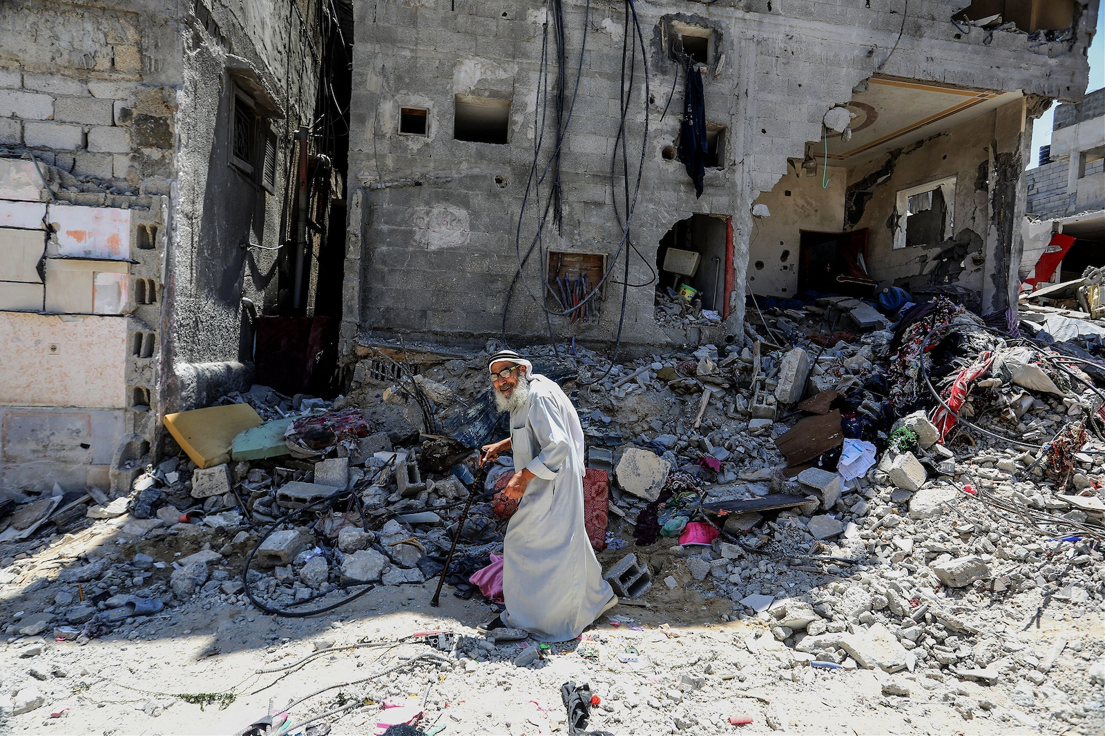 A Palestinian walks past destroyed homes in Gaza