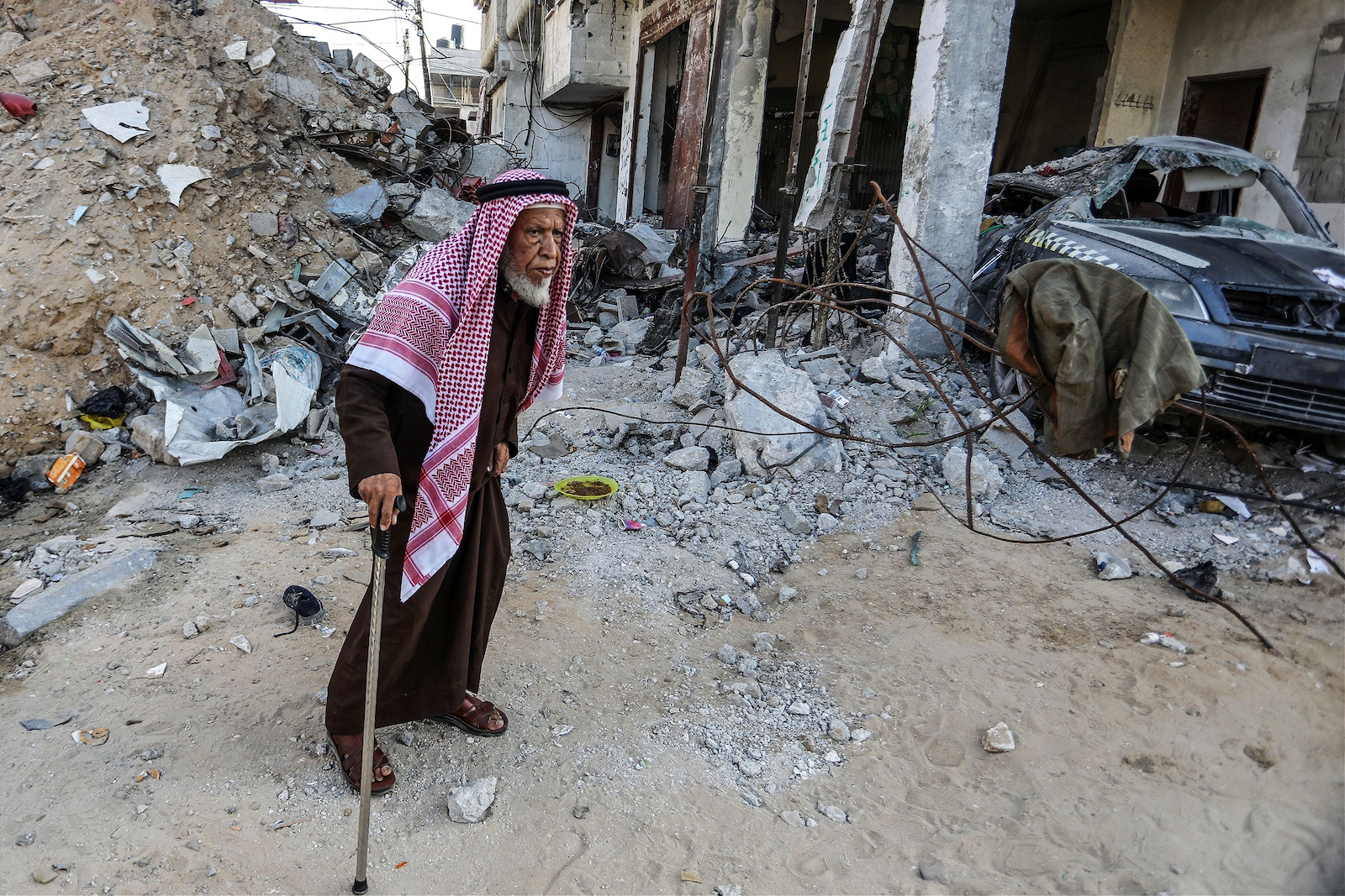 Palestinians inspect their destroyed house after an Israeli air strike, in the city of Rafah, south of the Gaza Strip