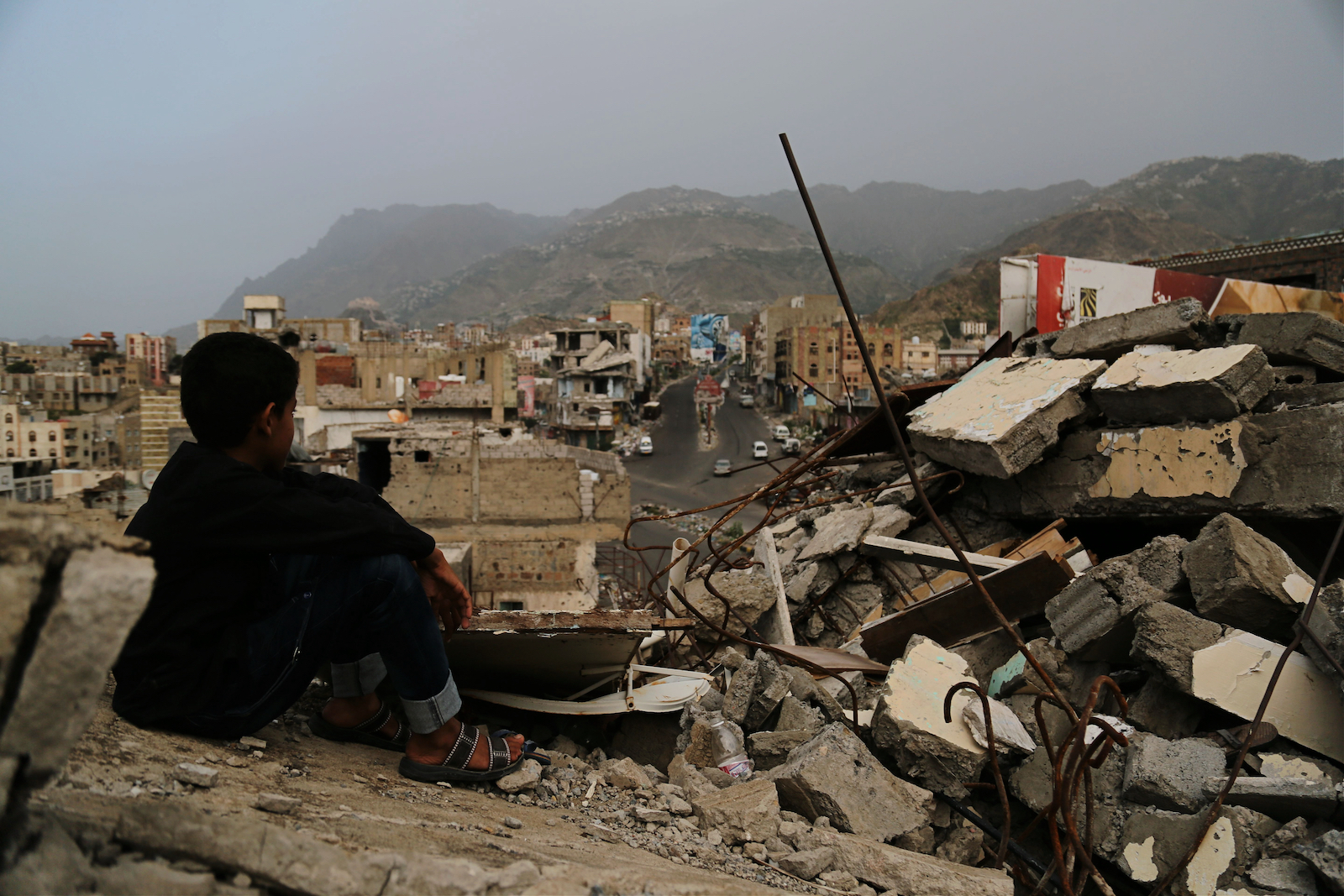 A Yemeni child sits in the ruins of his home in Taizz