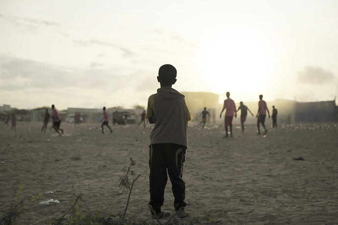 Young children playing football next to a camp for internally displaced persons in Mogadishu in 2017