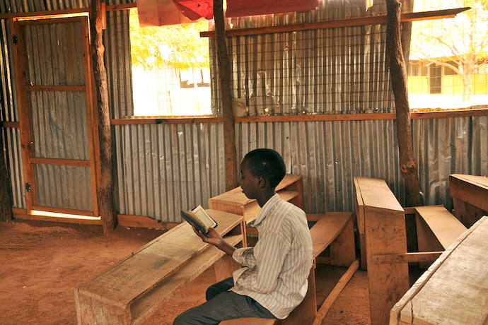 A young child reading the Qur'an in his classroom in Dadaab, Somalia