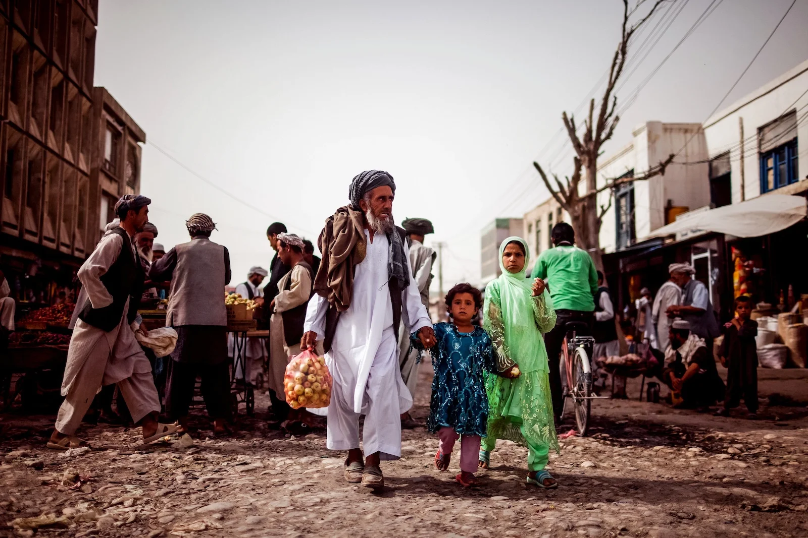 An Afghan family walking through a market in Mazar-i-Sharf