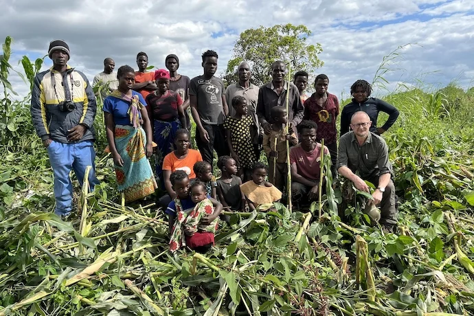 The author with Abuld Mumba and his family on the Zambian side of Kasungu, standing in an unharvested corn field that was flattened by a herd of elephants the night before