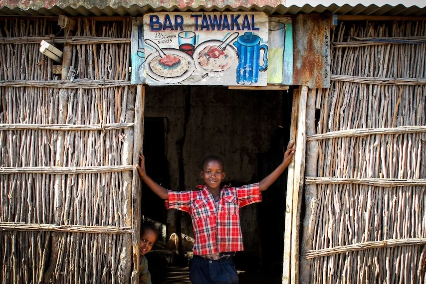 A Somali boy stands in the doorway of a roadside restaurant in the town of Buur-Hakba