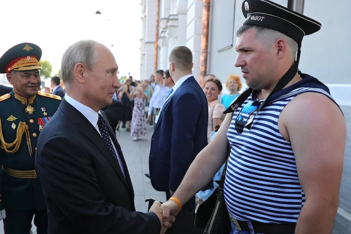 Vladimir Putin shaking hands with a Russian sailor