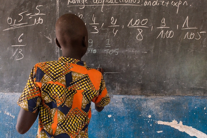 A child attends school in a refugee camp after escaping fighting