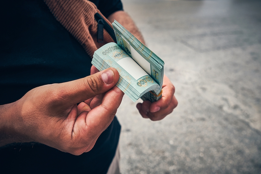 Man counting Lebanese banknotes