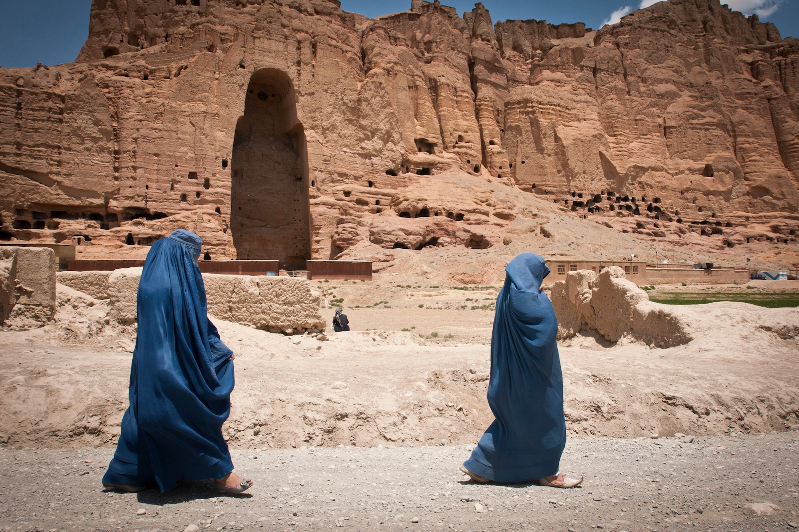 Two women walk past the huge cavity where one of the ancient Buddhas of Bamiyan